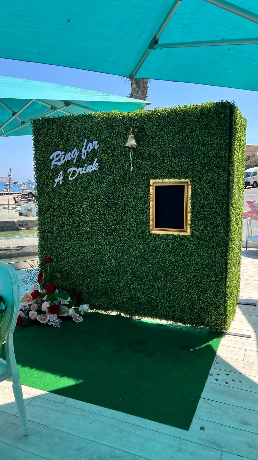Green hedge backdrop with Ring for a Drink styling at an outdoor celebration